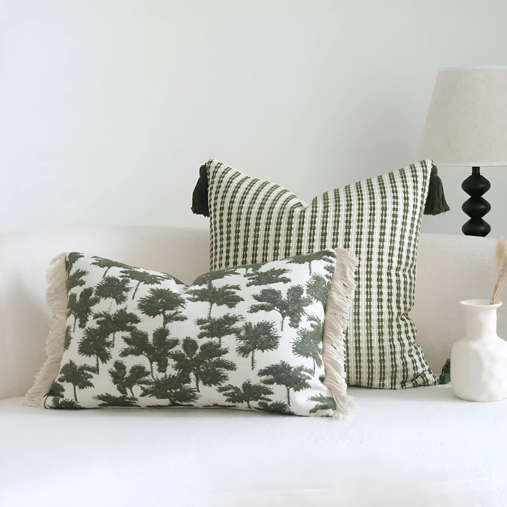 Green striped and botanical pattern decorative pillow set with tassel detail for hotel sample rooms.