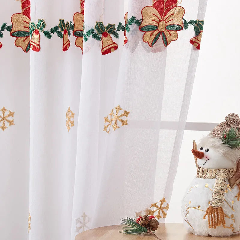 Pair of red and white Christmas curtains with embroidered snowflake design, showing light filtering through.