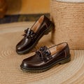 Black and brown women's round toe leather boots with chunky flat heels on display