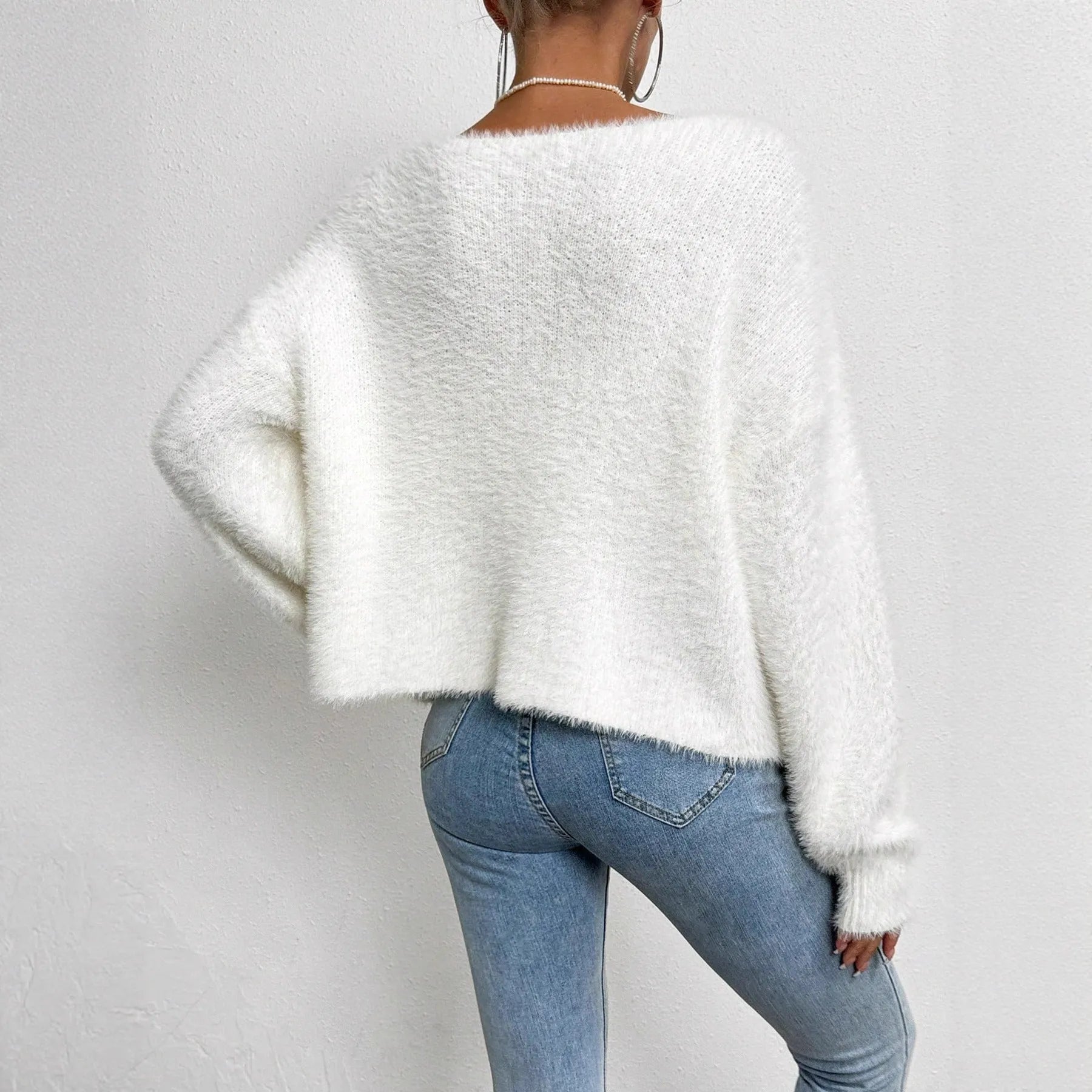 White women's V-neck cardigan sweater made from polyester knit fabric