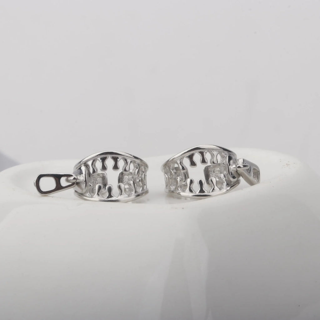A pair of silver-tone geometric openwork clip-on earrings with a zipper design detail.