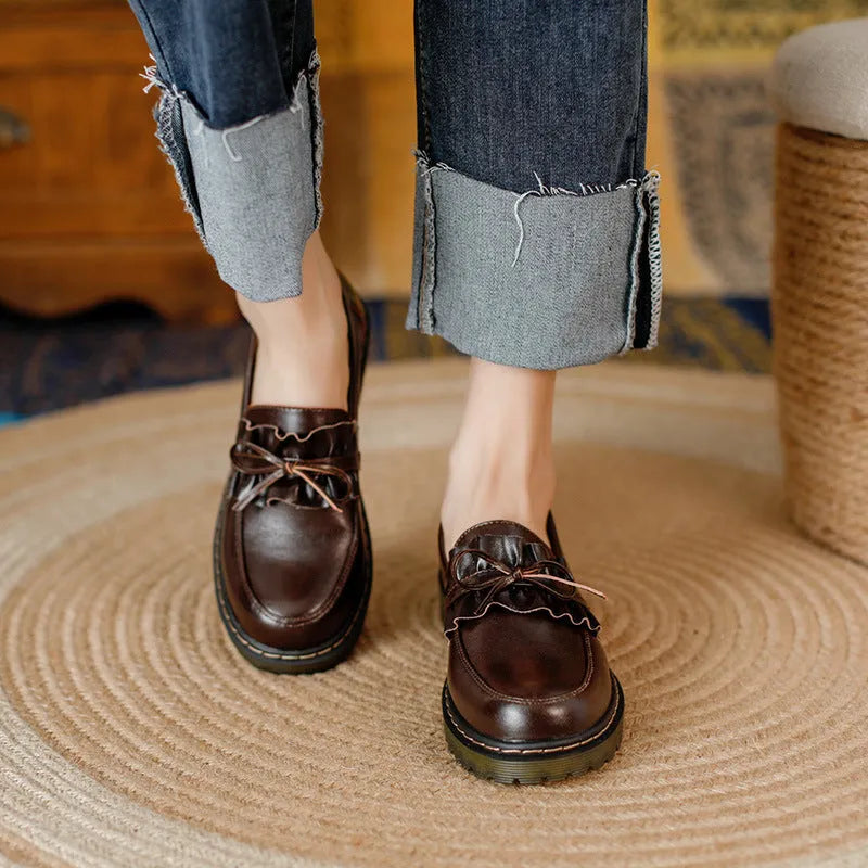 Black and brown women's round toe leather boots with chunky flat heels on display