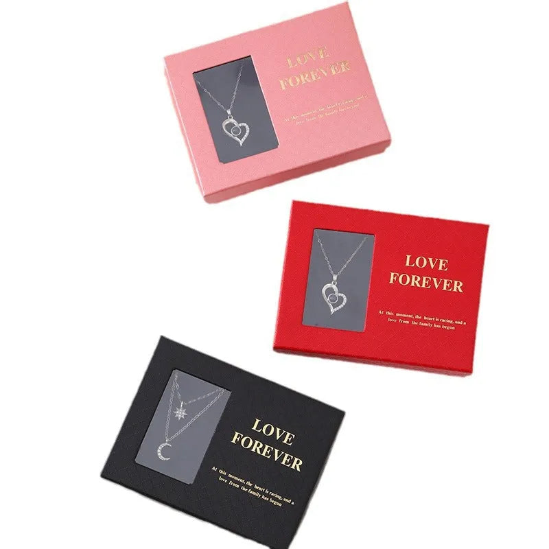 Red, pink, and black soap flower gift sets presented in a box with a handbag-style carrier.