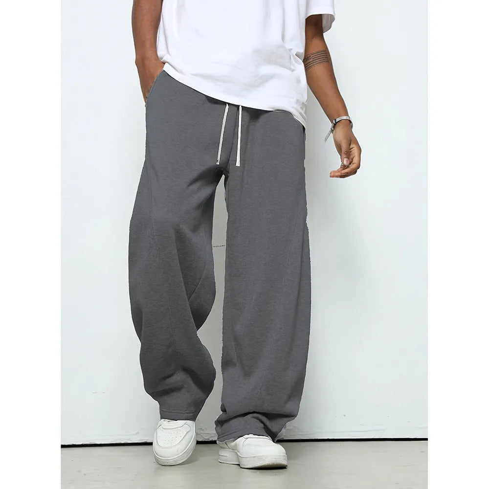 Men's straight-leg casual trousers in black with a drawstring waist, shown flat.