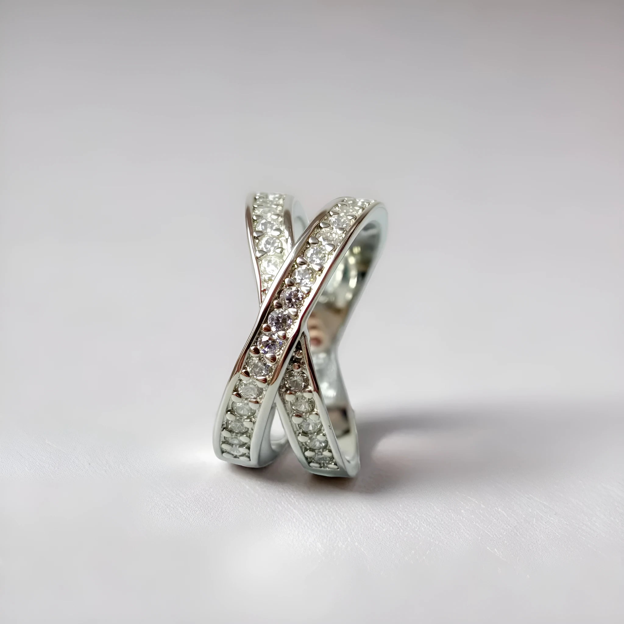 A simple copper ring with a metal cross design featuring micro-inlaid zircon, shown in rose gold and silver tone finishes.