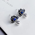 Blue Lotus earrings with a flower stud and dangling seedpod tassel in silver-tone alloy.
