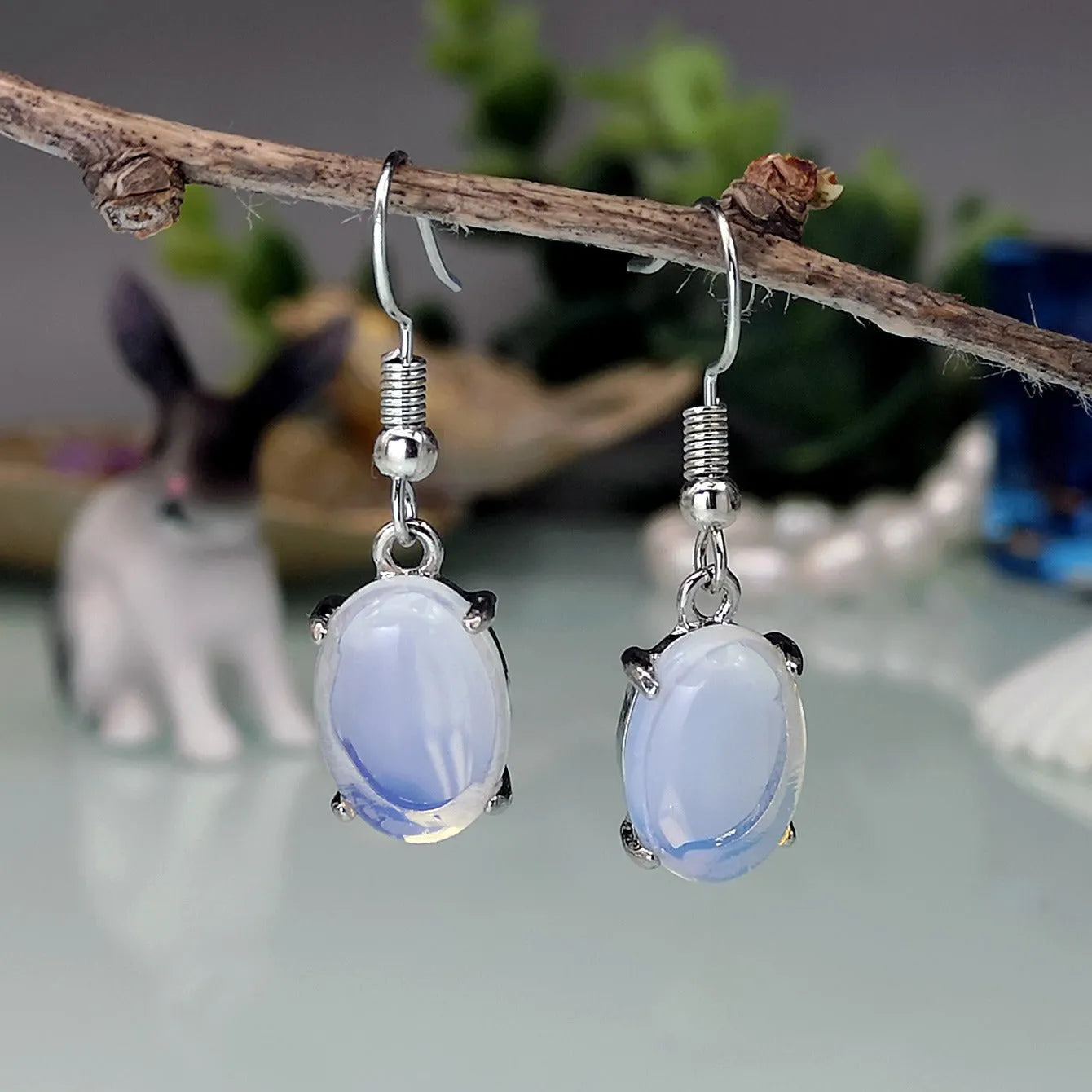 Moonlight white opal earrings with cross shaped drop design and retro moonstone appearance