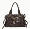 Women's brown soft PU French retro motorcycle shoulder messenger bag with woven design on a table.