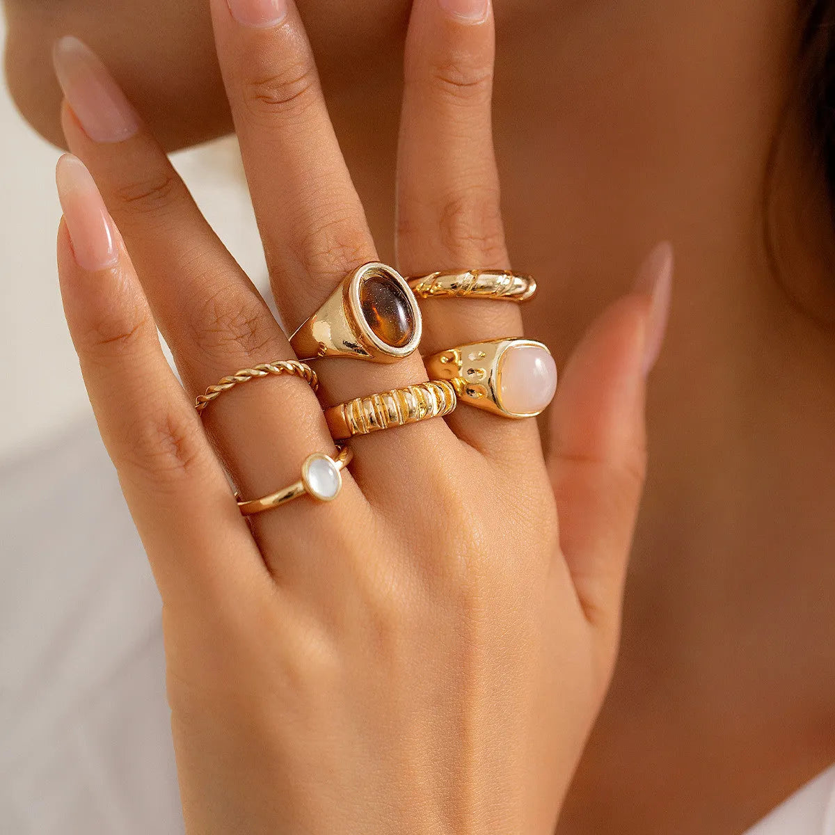 Six light gold geometric alloy rings with irregular shapes and electroplated finish arranged as a complete set