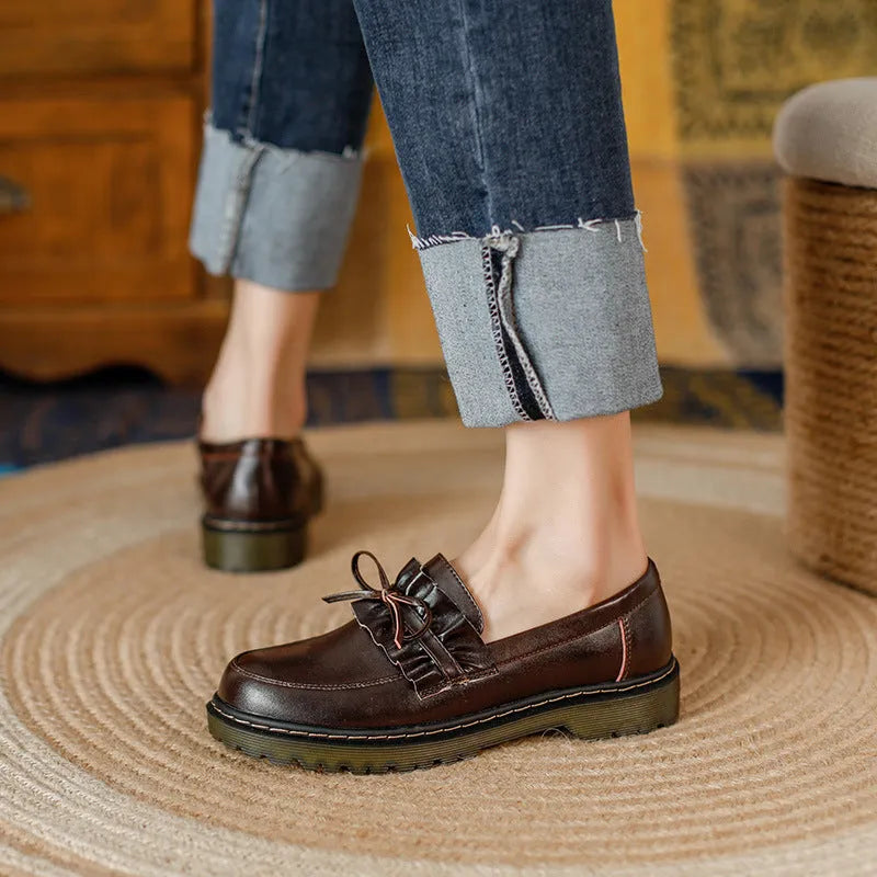 Black and brown women's round toe leather boots with chunky flat heels on display