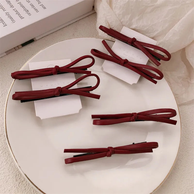 Wine red leather bow hair barrettes showing bow detail and clip mechanism