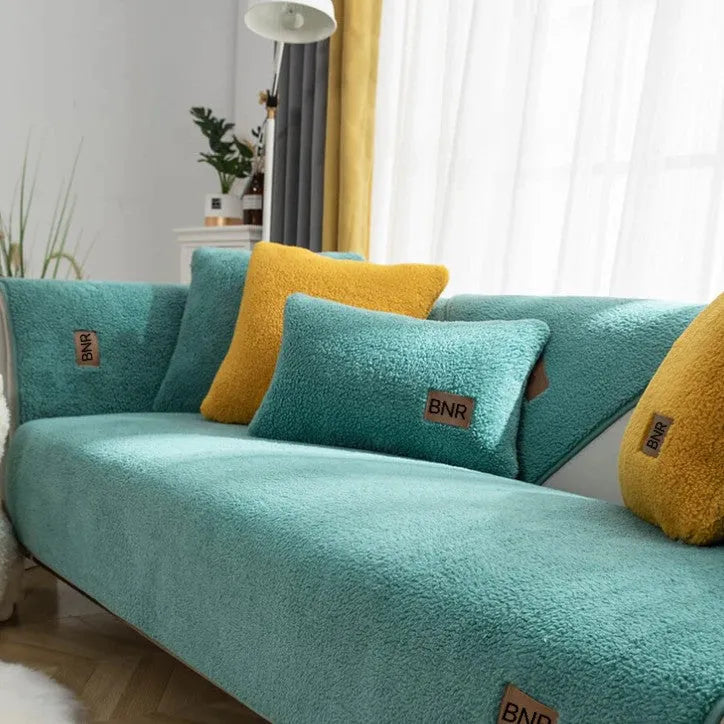 Lambswool sofa slipcover in blue on a three-seater sofa with matching cushion cover.