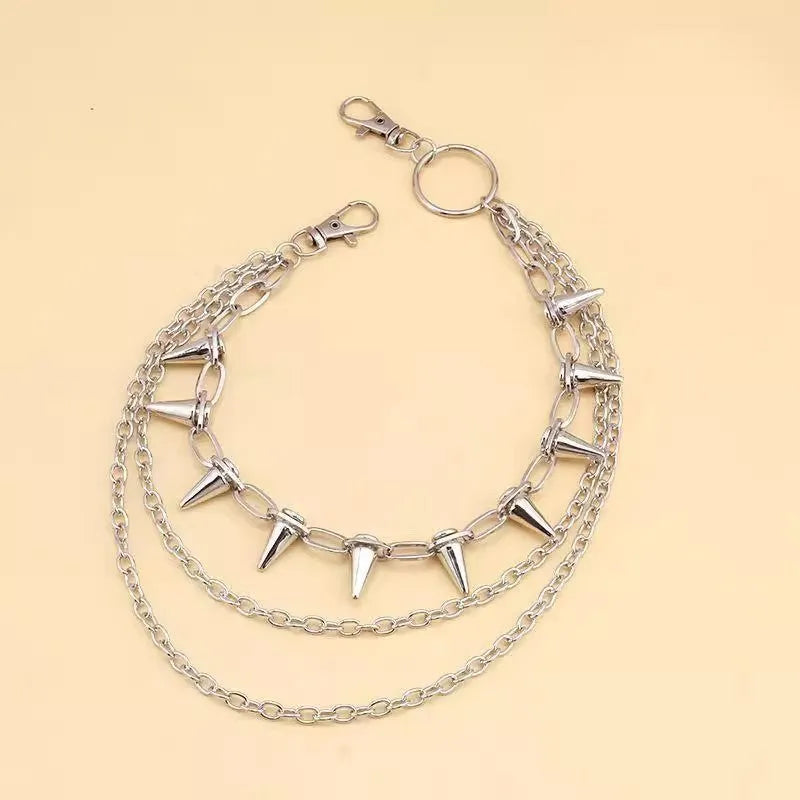Silver punk pants chain with double layers, zipper detail, and rivet accents against dark background