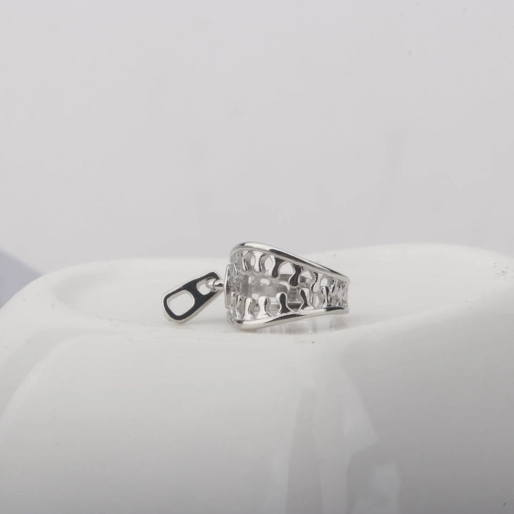 A pair of silver-tone geometric openwork clip-on earrings with a zipper design detail.
