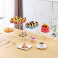 White plastic cube dessert display stand with six modular stacking components for cake presentation