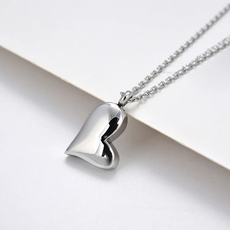 Silver curved peach heart pendant on stainless steel chain with extension