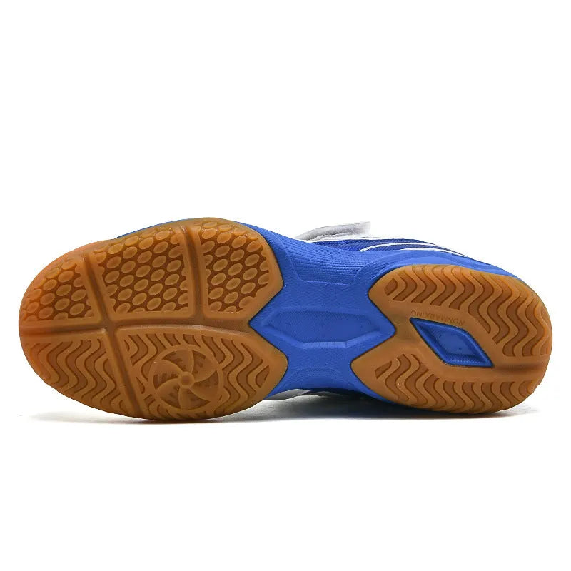 White and blue low-top casual badminton shoes with ribbed sole on a court surface.