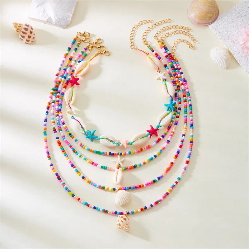 Five-piece women's necklace set with shell beads and adjustable chains in blue and coloured variations