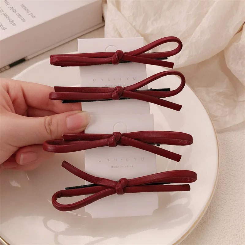 Wine red leather bow hair barrettes showing bow detail and clip mechanism