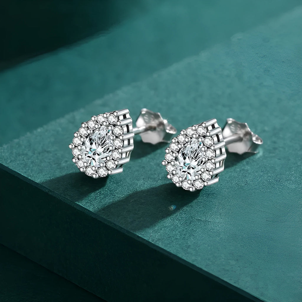 Close-up of women's sterling silver water drop shaped ear studs with diamond cut facets on a white background.