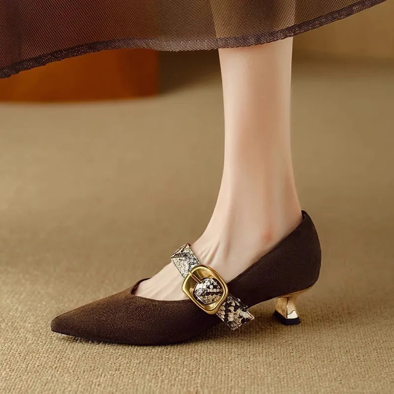 Black women's stiletto high heels with pointed toe and decorative ankle buckle on a rubber sole.