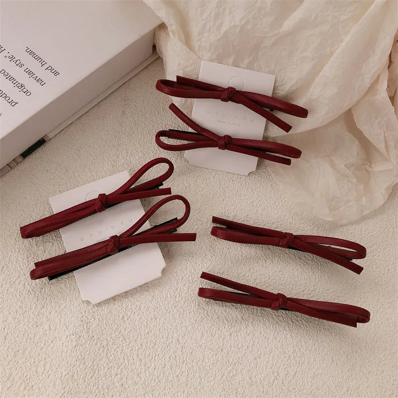 Wine red leather bow hair barrettes showing bow detail and clip mechanism
