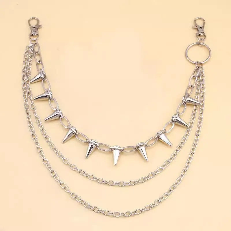 Silver punk pants chain with double layers, zipper detail, and rivet accents against dark background