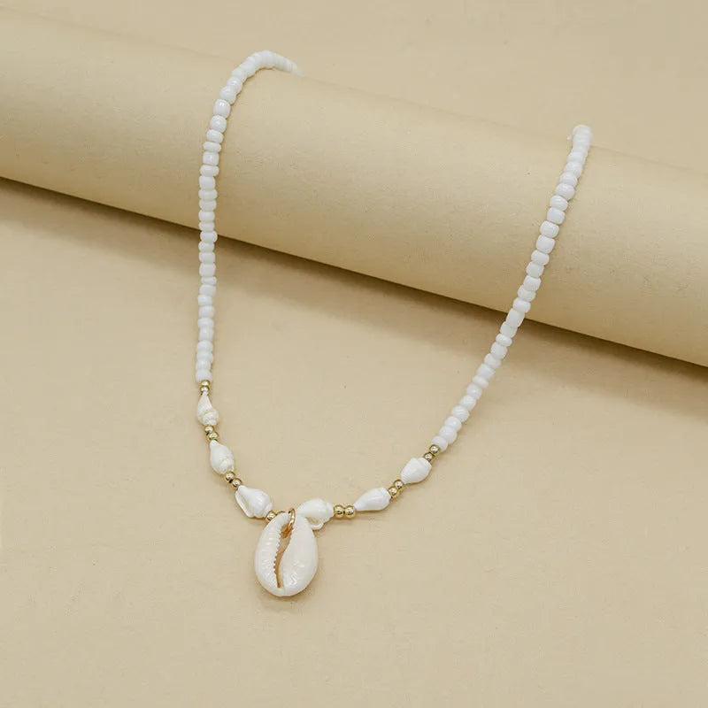 White necklace with a conch shell pendant made from Mother Pearl shellfish on an electroplated chain.