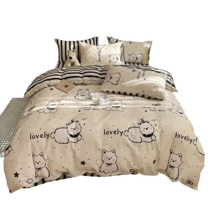 Cartoon dog patterned cotton four-piece bedding set laid on a bed.