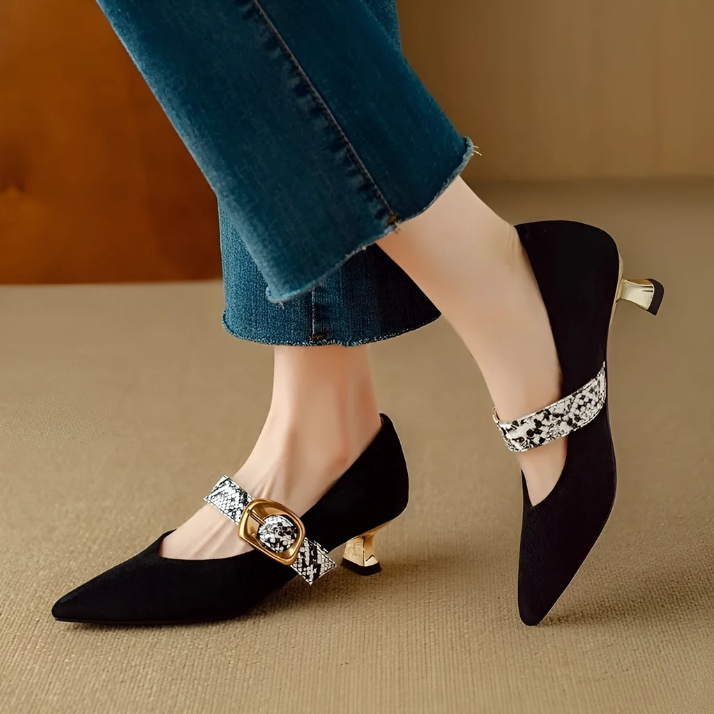 Black women's stiletto high heels with pointed toe and decorative ankle buckle on a rubber sole.
