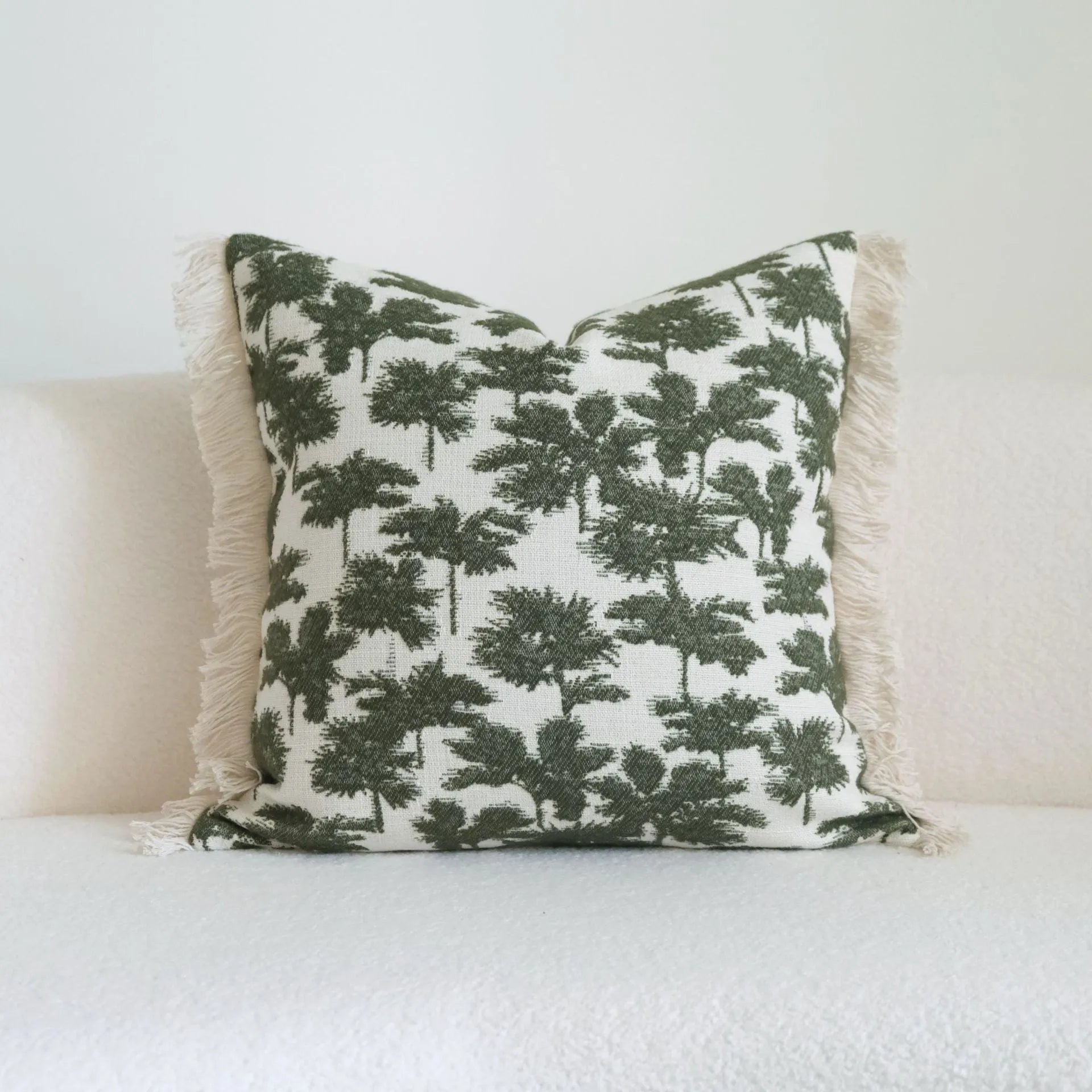 Green striped and botanical pattern decorative pillow set with tassel detail for hotel sample rooms.