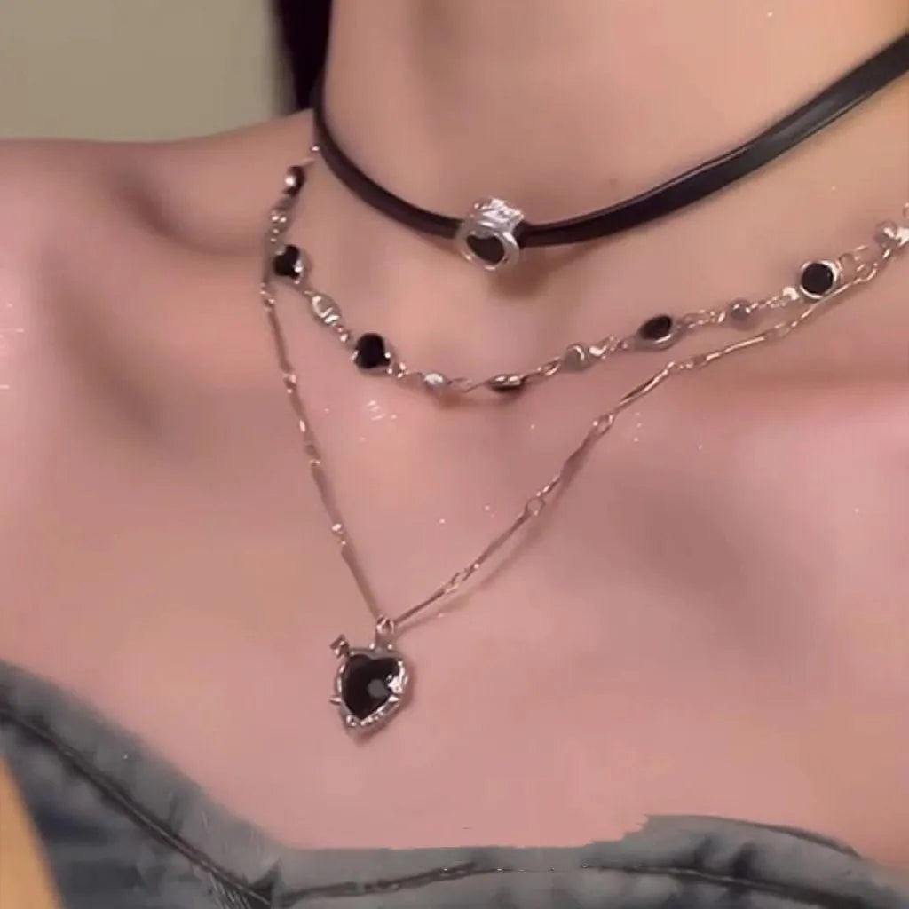 Women's creative necklace set showing a double-layer leather heart necklace and a single crystal heart pendant on a metal chain.