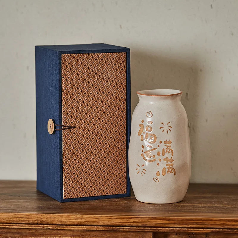 Chinese hand-painted ceramic vase with carved design on wooden desktop