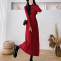 Women's beige knitted mid-length coat dress with A-line skirt and high waist on a model.