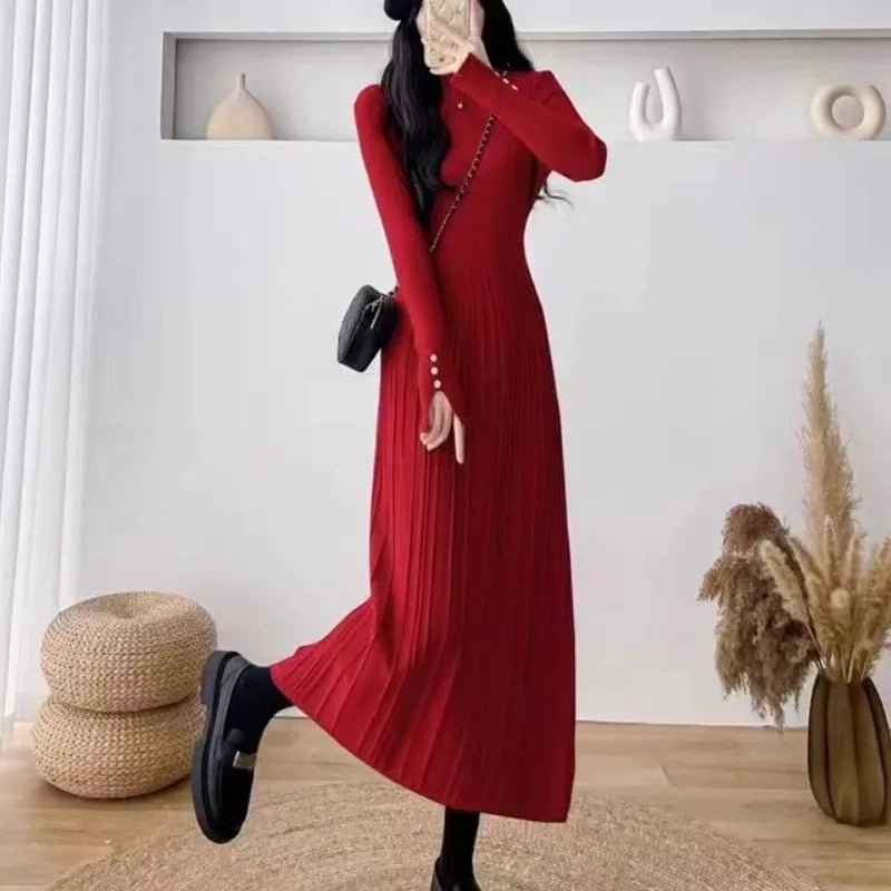 Women's beige knitted mid-length coat dress with A-line skirt and high waist on a model.