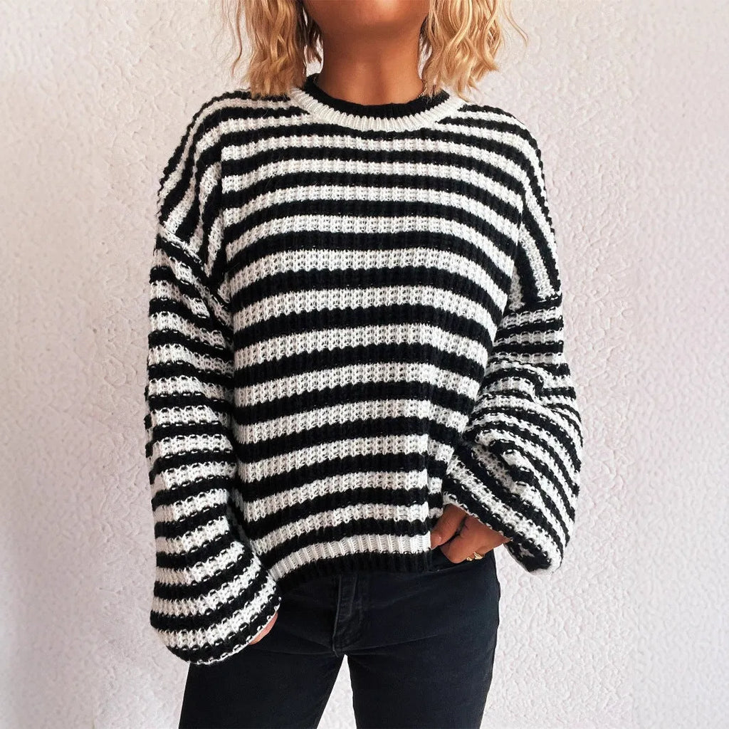 Woman wearing loose striped knit sweater in vintage style with round neck and long sleeves