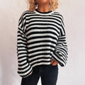 Woman wearing loose striped knit sweater in vintage style with round neck and long sleeves