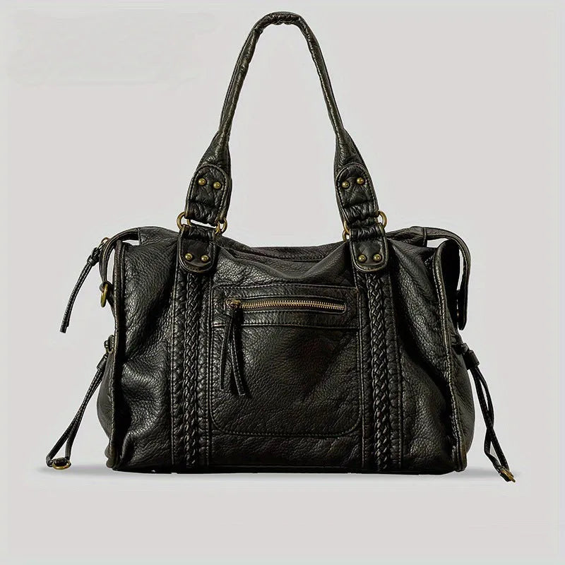 Women's brown soft PU French retro motorcycle shoulder messenger bag with woven design on a table.