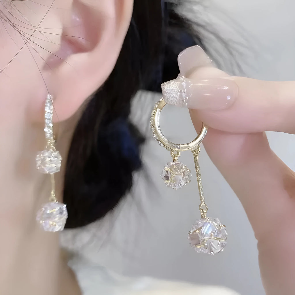Women's silver-toned drop earrings with a double pendant and rhinestone ball tassel on an ear clip.