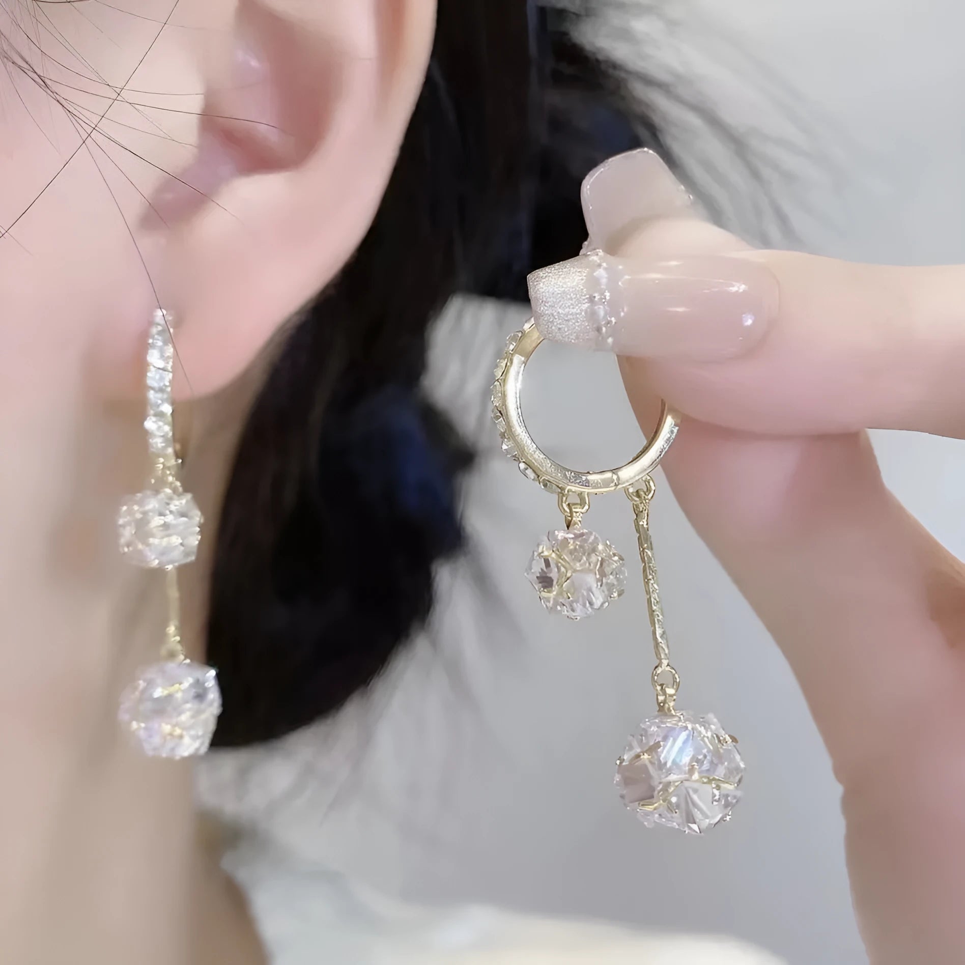 Women's silver-toned drop earrings with a double pendant and rhinestone ball tassel on an ear clip.