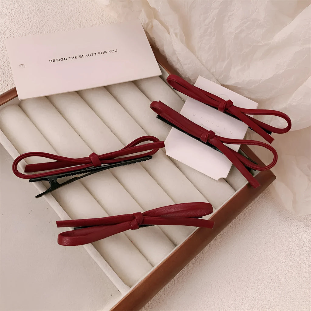Wine red leather bow hair barrettes showing bow detail and clip mechanism