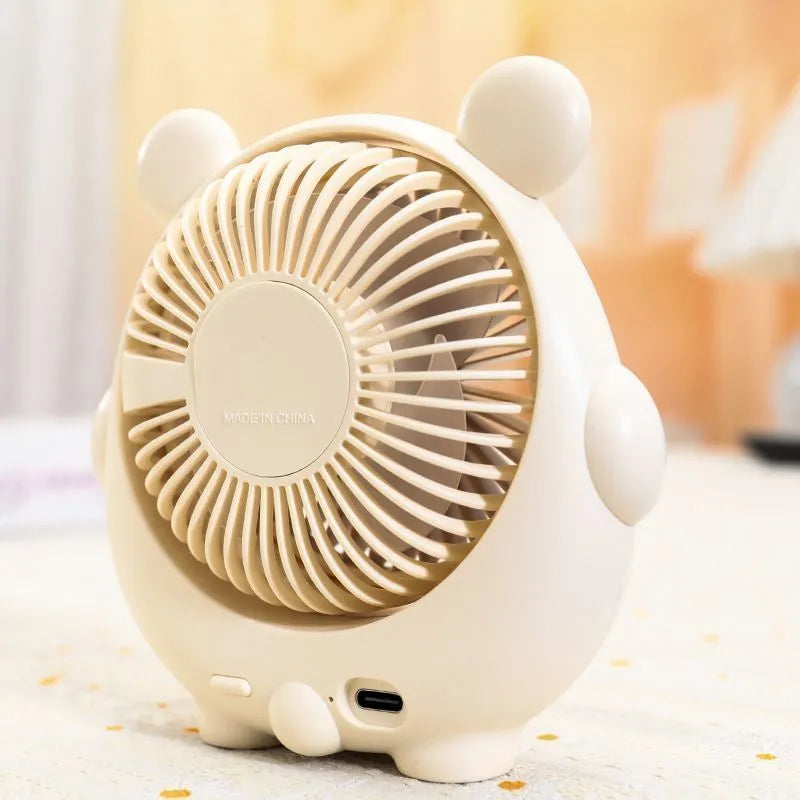 Cute dog shaped USB powered desk fan with three speed settings on a wooden table.