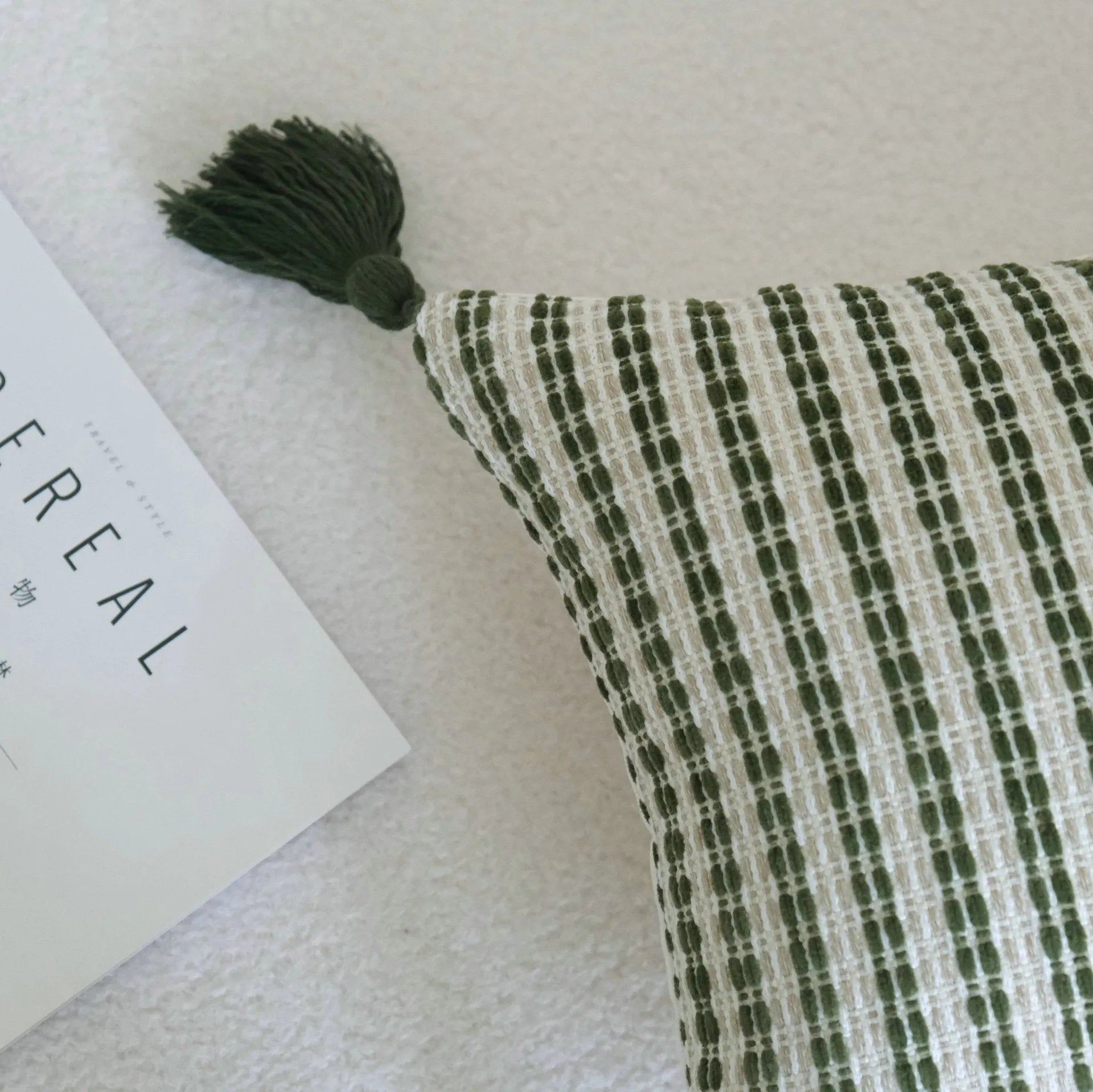 Green striped and botanical pattern decorative pillow set with tassel detail for hotel sample rooms.