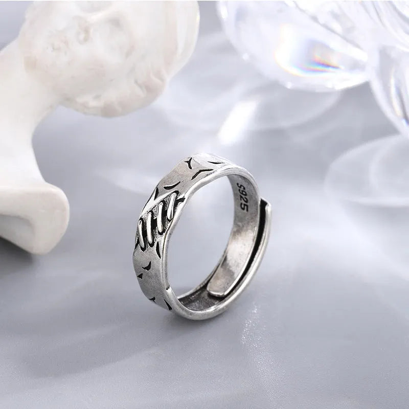 Black copper geometric ring with adjustable opening and round oval design elements.