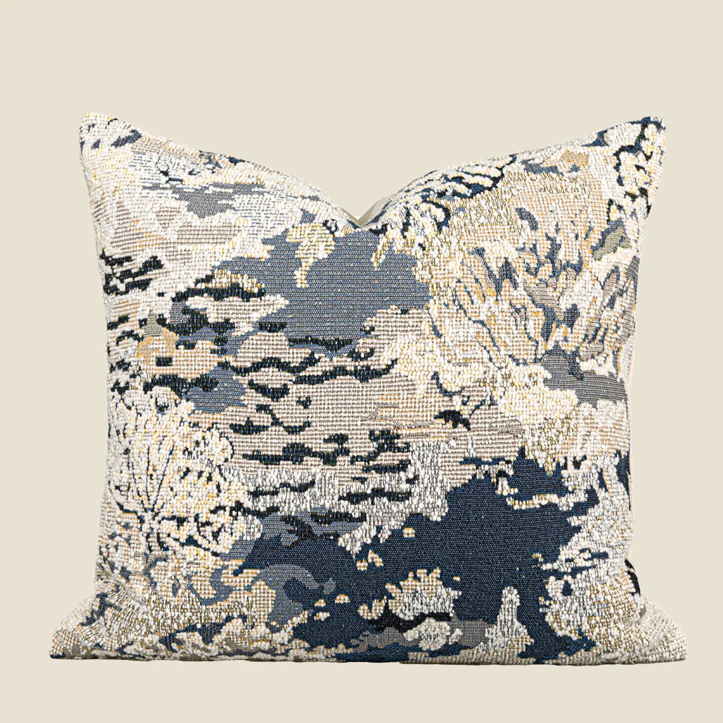 Antique blue French style decorative pillow with abstract floral pattern on a sofa.