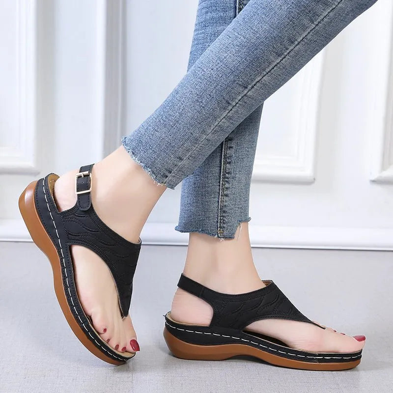 Women's wedge heel flip flop sandals in black with an adjustable back strap and buckle.