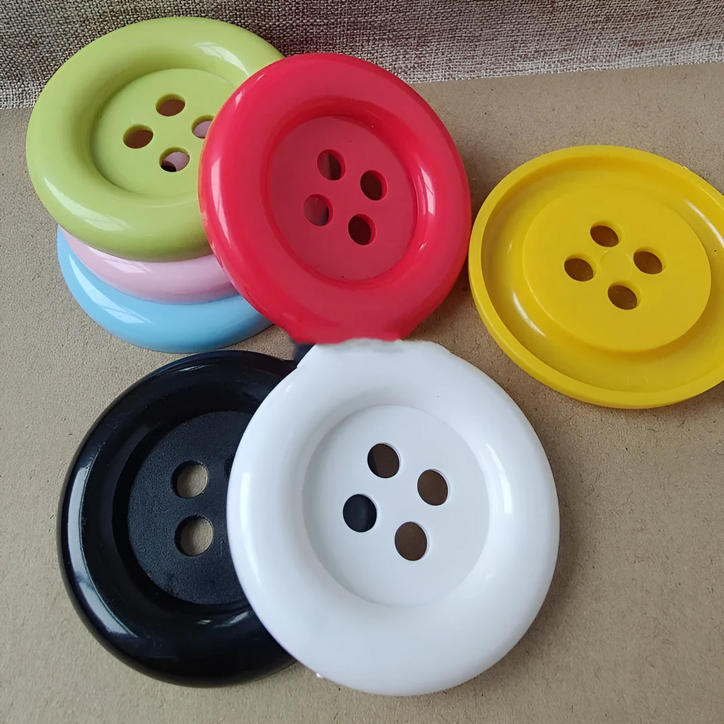 Assortment of oversized round plastic buttons in multiple colours showing four-hole design