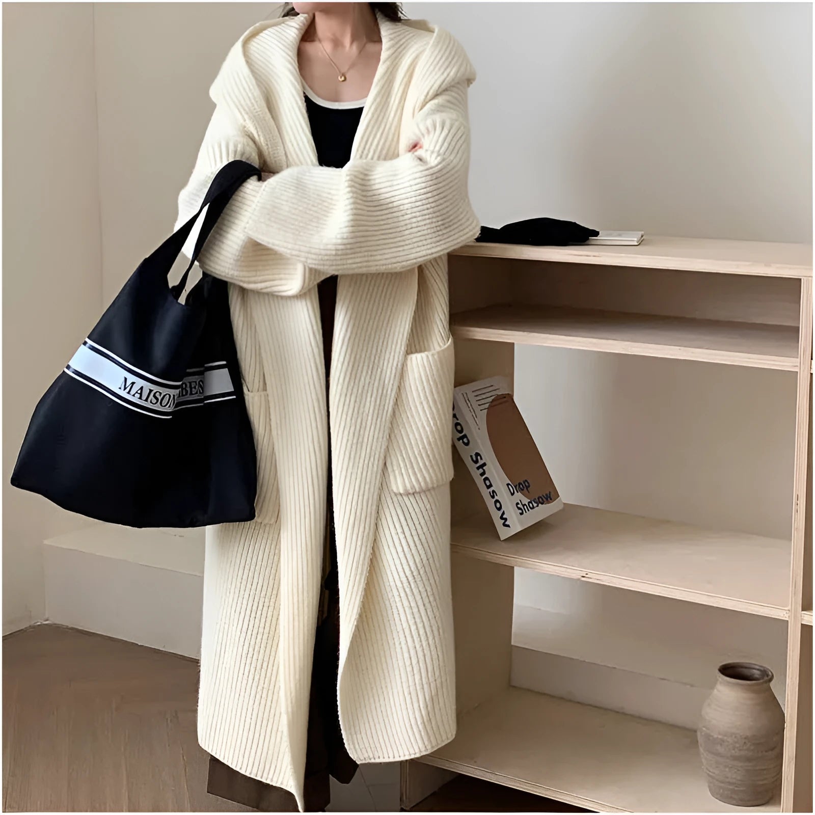 A woman wearing a longline milky white hooded cardigan sweatshirt with raglan sleeves.