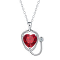 Close-up of a red diamond coloured stethoscope pendant necklace with cross, heart and wing details on a copper chain.