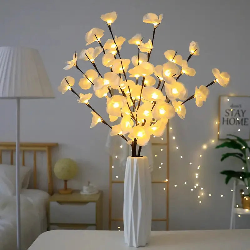 Pink LED phalaenopsis orchid branch decorative light on a dark surface.